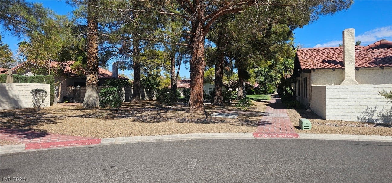 817 Spyglass Lane, Las Vegas, NV 89107 trees shade a paved walkway winding through the beautifully landscaped neighborhood common areas.