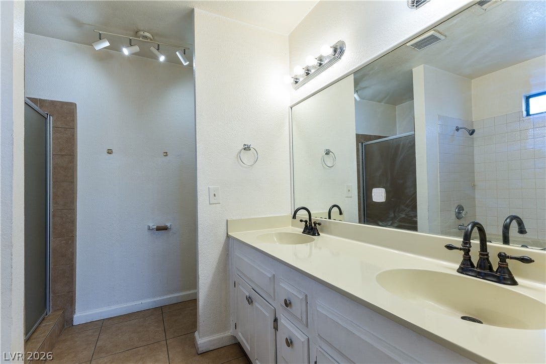 817 Spyglass Lane, Las Vegas, NV 89107 Functional layout features a dual-sink vanity and neutral tile flooring in the bathroom.
