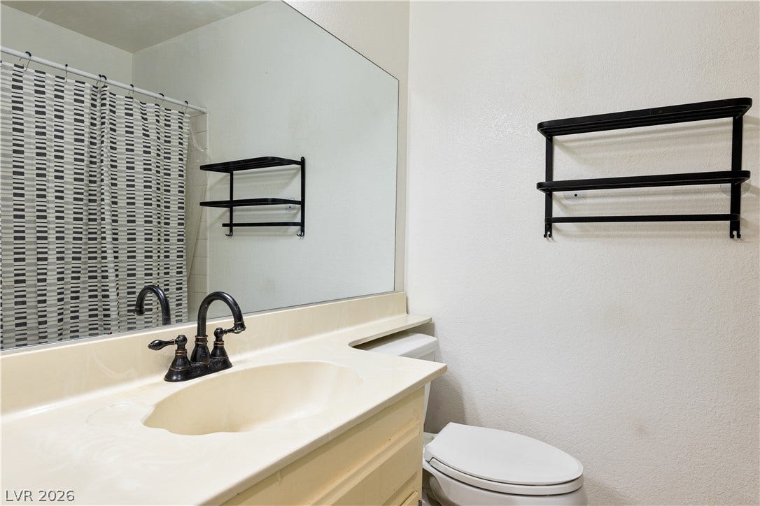 817 Spyglass Lane, Las Vegas, NV 89107 An integrated vanity countertop pairs with a broad mirror in this functional bathroom layout.