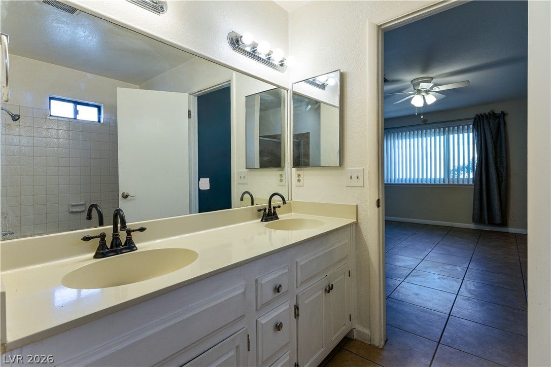 817 Spyglass Lane, Las Vegas, NV 89107 Double sinks and a large mirror highlight this functional, tiled bathroom space.