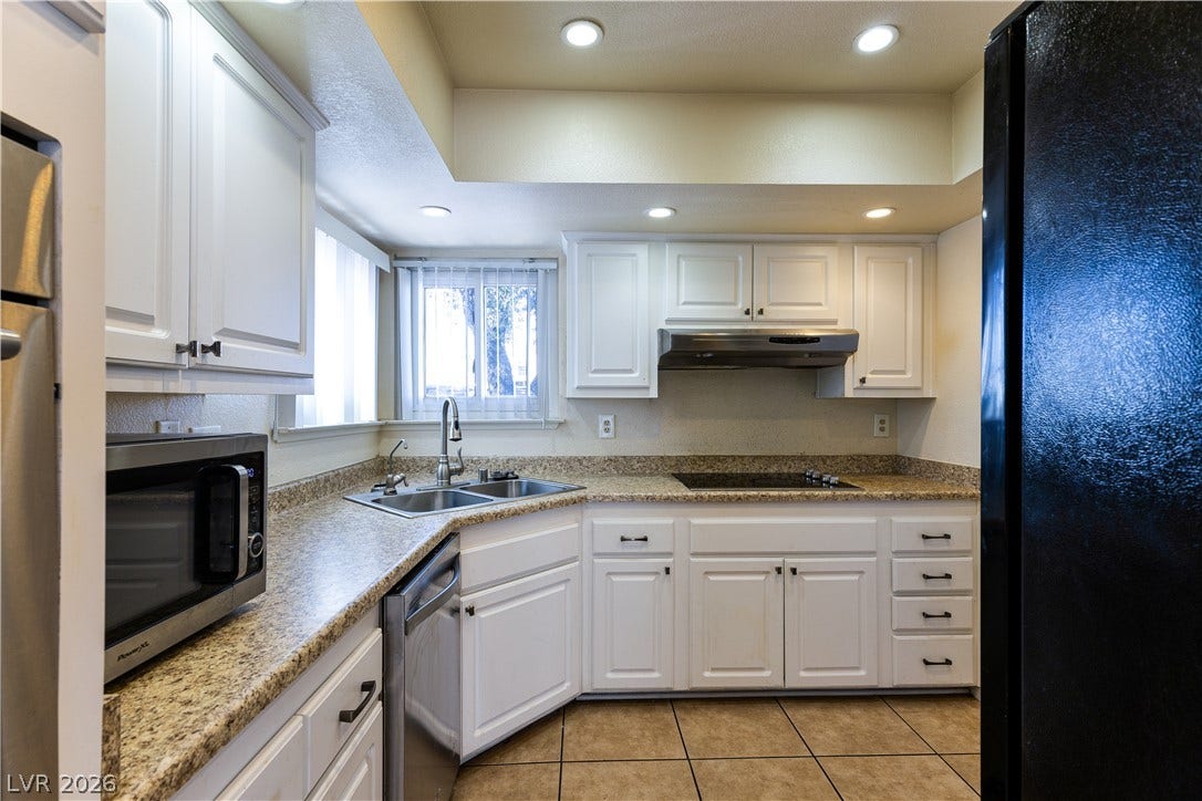 817 Spyglass Lane, Las Vegas, NV 89107 Timeless stone countertops and crisp white cabinetry define this functional, light-filled kitchen space.