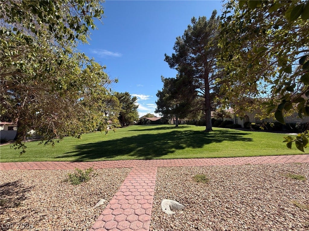 817 Spyglass Lane, Las Vegas, NV 89107 Trees, shade and green lawn bordered by paved brick walkways.