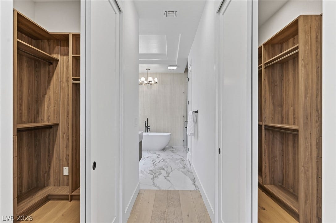 1900 Glenview Drive, Las Vegas, NV 89134 Custom wood shelving details this walk-in closet space leading directly into the main bath.