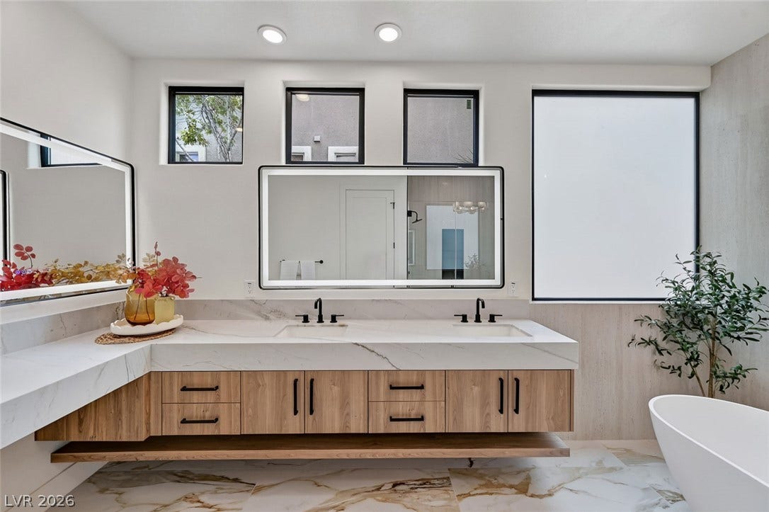 1900 Glenview Drive, Las Vegas, NV 89134 Streamlined floating vanities and stone countertops elevate this contemporary bathroom design.