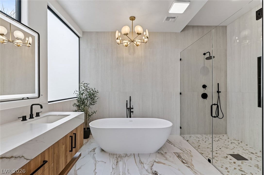 1900 Glenview Drive, Las Vegas, NV 89134 A modern soaking tub serves as the centerpiece of this marble-floored primary bathroom.