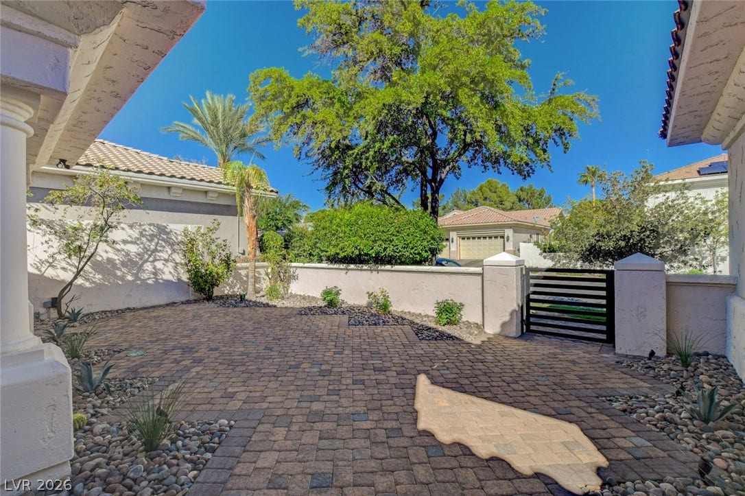 1900 Glenview Drive, Las Vegas, NV 89134 An inviting stone paver courtyard features low maintenance landscaping under a bright desert sky.
