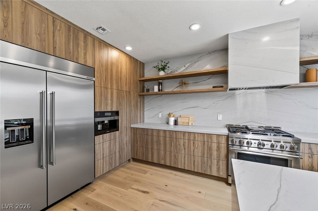 1900 Glenview Drive, Las Vegas, NV 89134 Streamlined wood grain cabinetry and matching stone backsplashes elevate this modern culinary space.