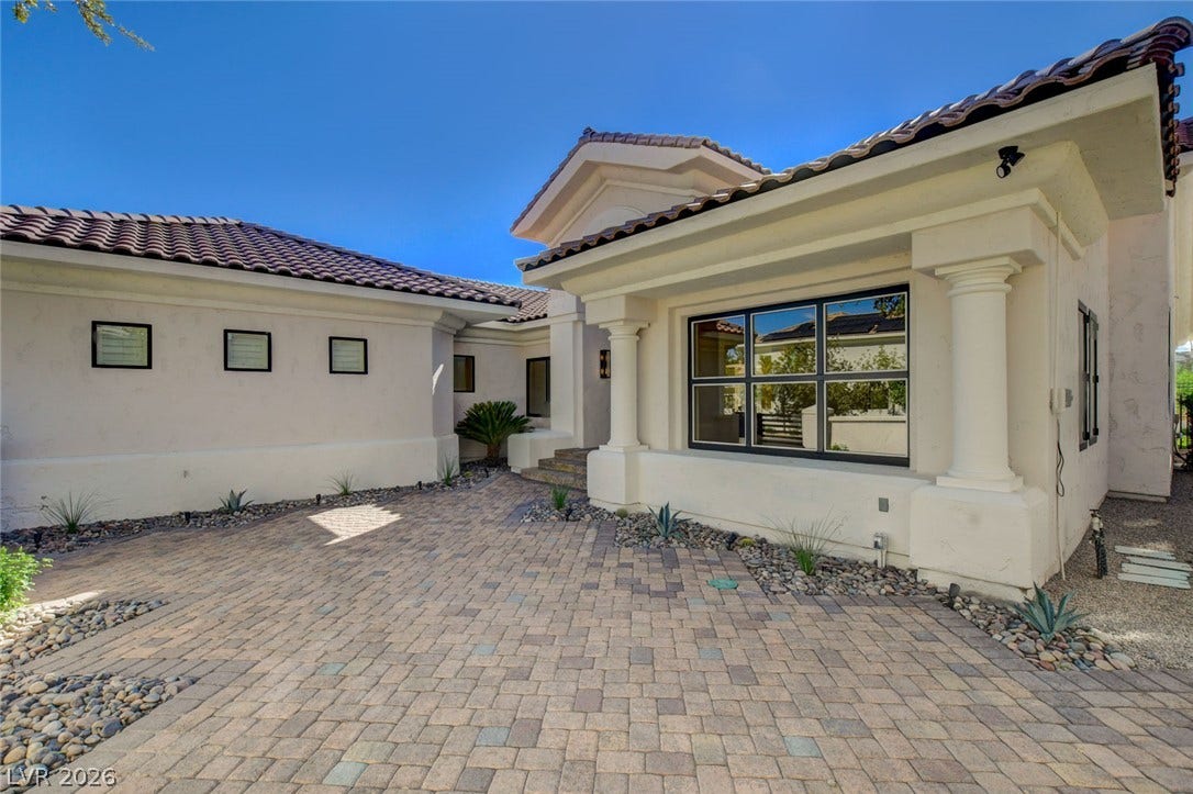 1900 Glenview Drive, Las Vegas, NV 89134 Classical columns and custom pavers frame the entryway of this modern Mediterranean exterior.
