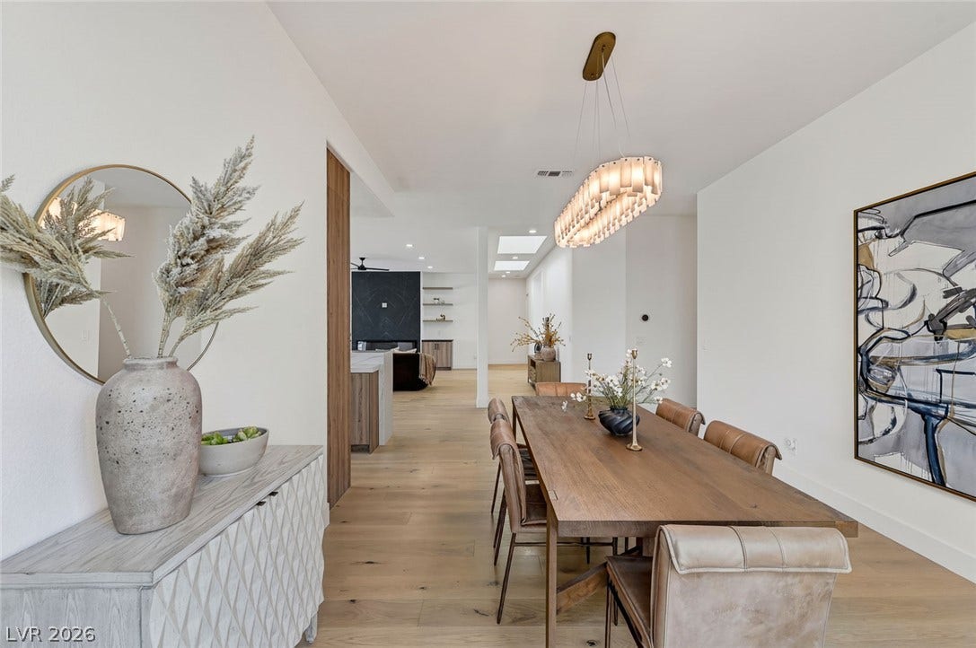 1900 Glenview Drive, Las Vegas, NV 89134 Gleaming hardwood floors and a modern linear chandelier define this inviting dining room.