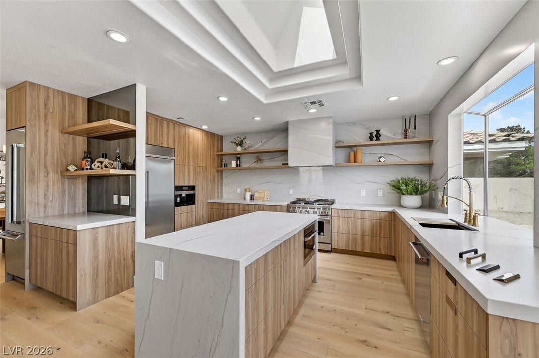 1900 Glenview Drive, Las Vegas, NV 89134 Gleaming stone countertops and warm wood cabinetry define this modern kitchen under a geometric skylight.