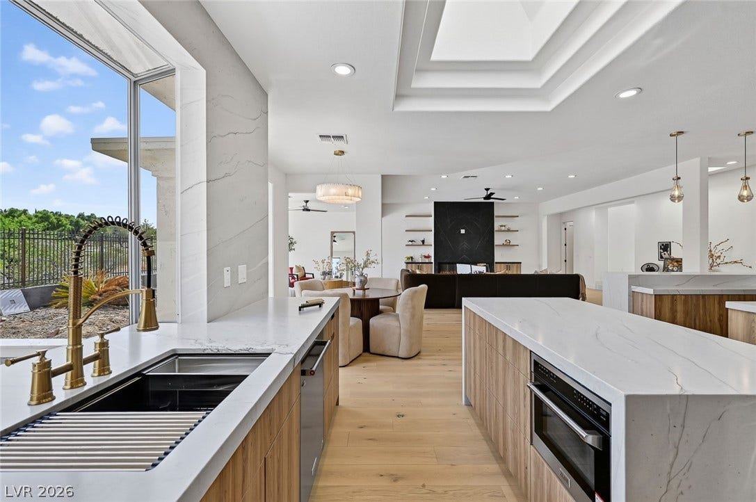 1900 Glenview Drive, Las Vegas, NV 89134 An open floorplan seamlessly connects the stone-countertop kitchen with the surrounding living spaces.