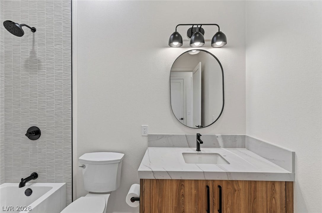 1900 Glenview Drive, Las Vegas, NV 89134 A modern vanity with stone counters and a sleek shower flank this clean bathroom.