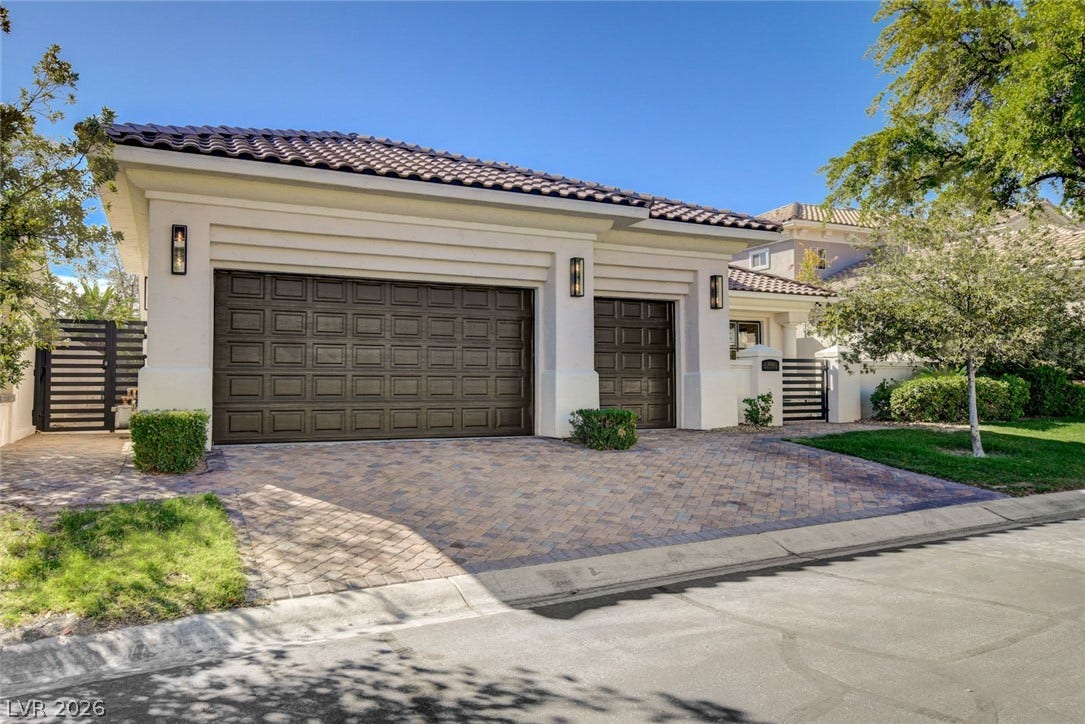 1900 Glenview Drive, Las Vegas, NV 89134 Elegant tile roofing and a spacious paver driveway highlight the three-car garage facade.