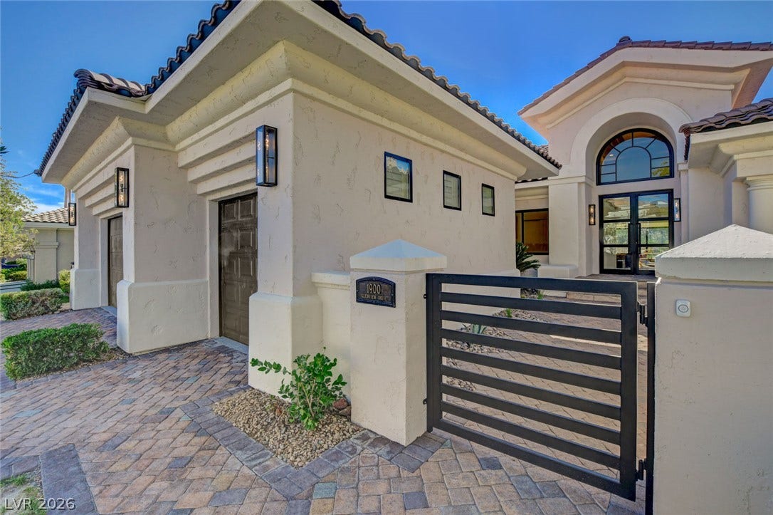 1900 Glenview Drive, Las Vegas, NV 89134 Gated entry pathways paved in textured stone lead toward a grand arched glass entryway.
