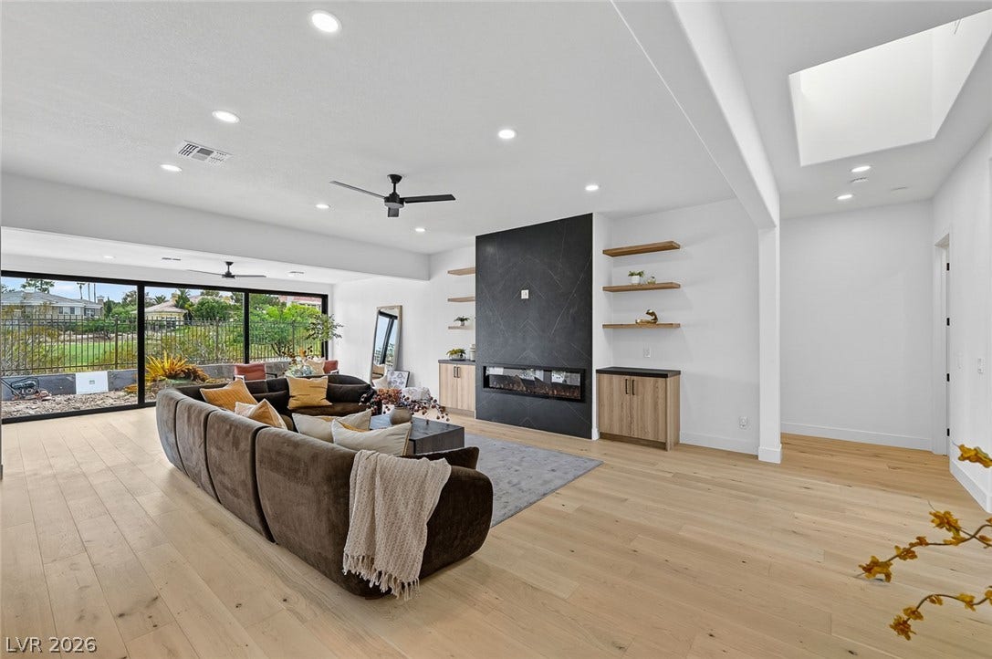 1900 Glenview Drive, Las Vegas, NV 89134 A modern fireplace anchors this bright living space defined by light hardwood floors.