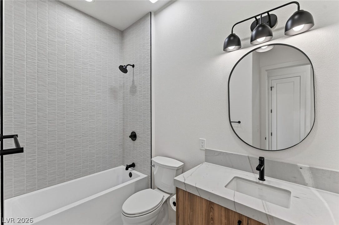 1900 Glenview Drive, Las Vegas, NV 89134 Modern finishes define this bathroom, highlighted by textured shower tiling and stone-look counters.