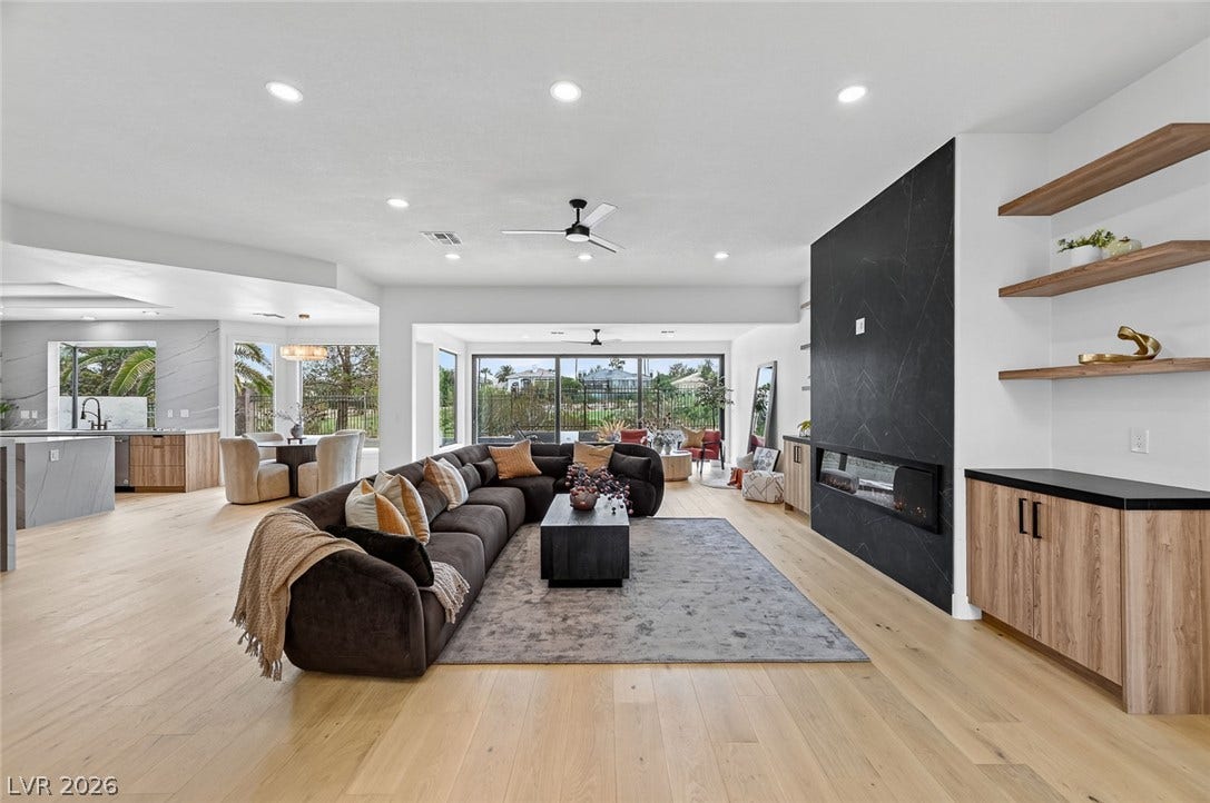 1900 Glenview Drive, Las Vegas, NV 89134 A modern open concept living room highlights light wood flooring and a sleek fireplace wall.