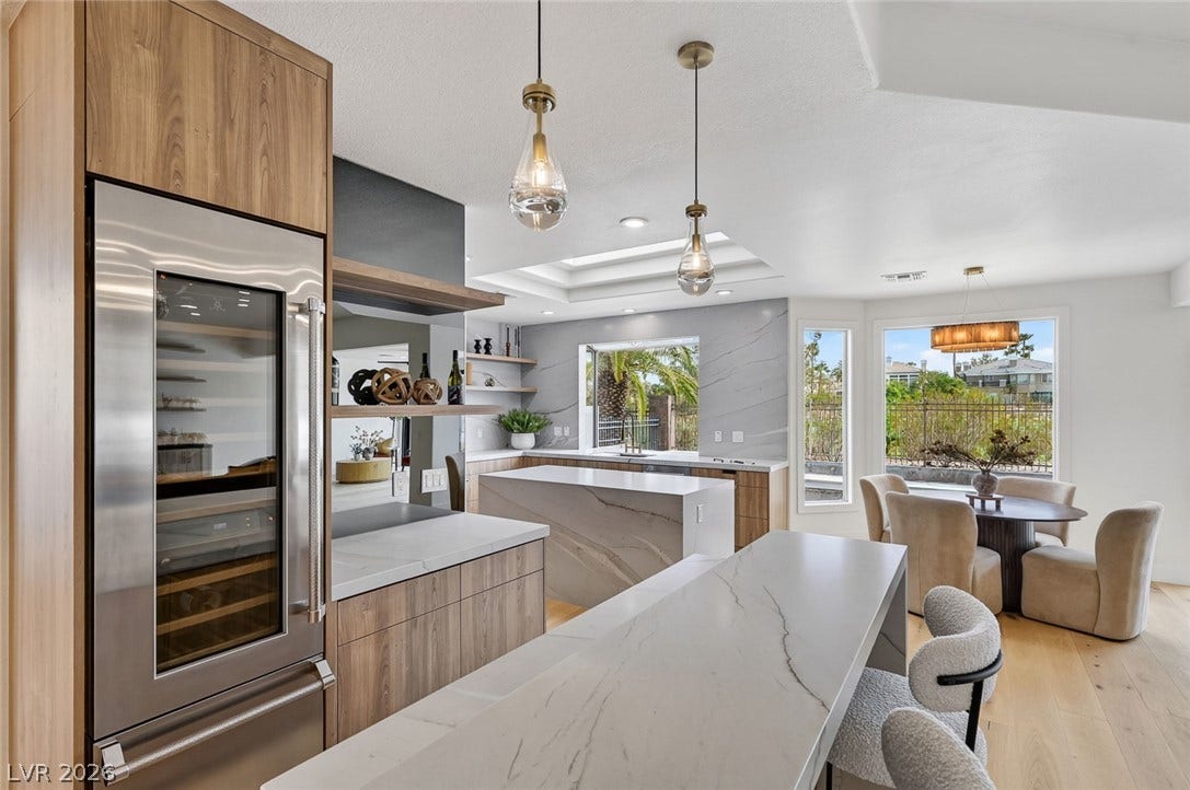 1900 Glenview Drive, Las Vegas, NV 89134 Gleaming stone countertops and warm wood cabinetry anchor this light-filled modern kitchen space.