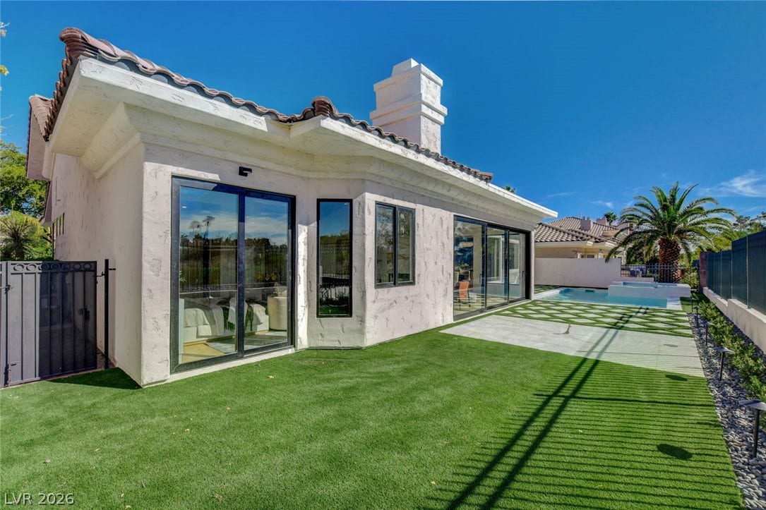 1900 Glenview Drive, Las Vegas, NV 89134 Sliding glass doors connect the stucco exterior to a manicured lawn and pool area.
