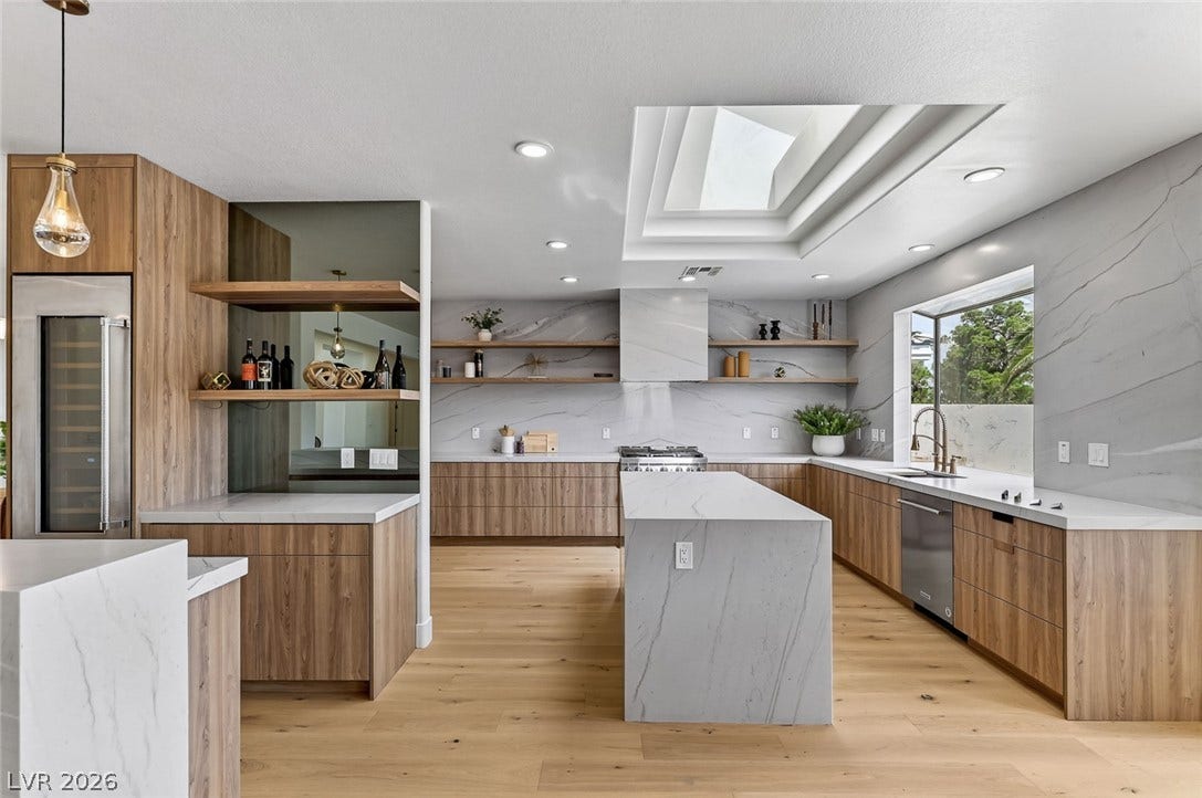 1900 Glenview Drive, Las Vegas, NV 89134 A spacious culinary space showcases rich wood cabinetry, extensive stone countertops, and a central skylight.