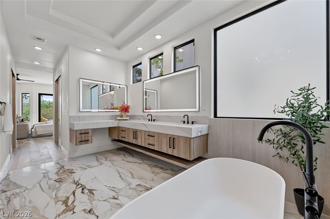 1900 Glenview Drive, Las Vegas, NV 89134 A spacious layout features a freestanding tub and floating dual vanities over marble-tiled floors.