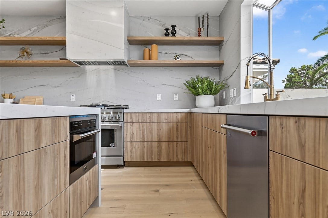 1900 Glenview Drive, Las Vegas, NV 89134 Warm wood cabinetry pairs with elegant stone surfaces in this light-filled modern kitchen.