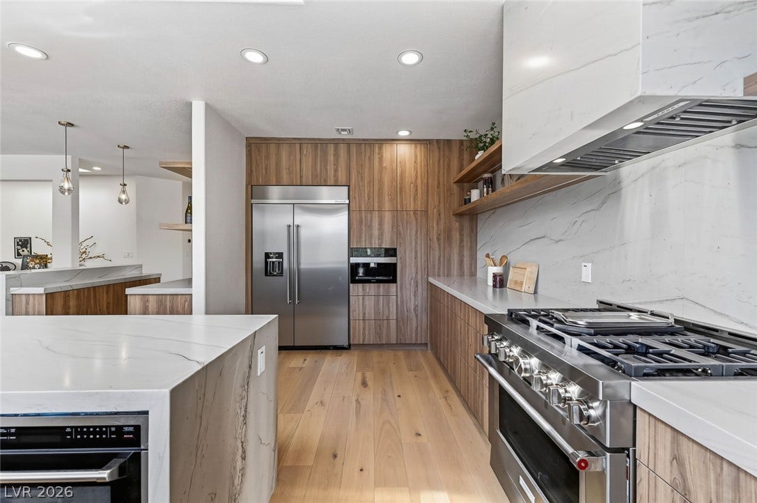 1900 Glenview Drive, Las Vegas, NV 89134 Gleaming stone countertops and integrated appliances define this modern kitchen workspace.