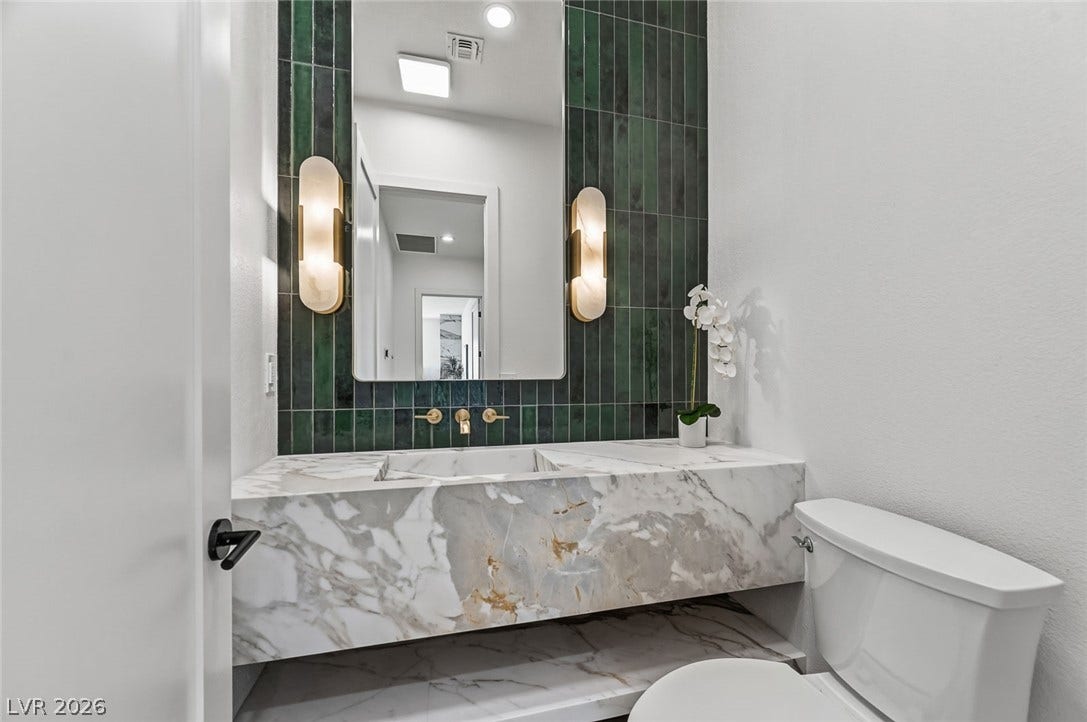 1900 Glenview Drive, Las Vegas, NV 89134 Striking marble counters and vertical wall tile anchor this modern powder bath.