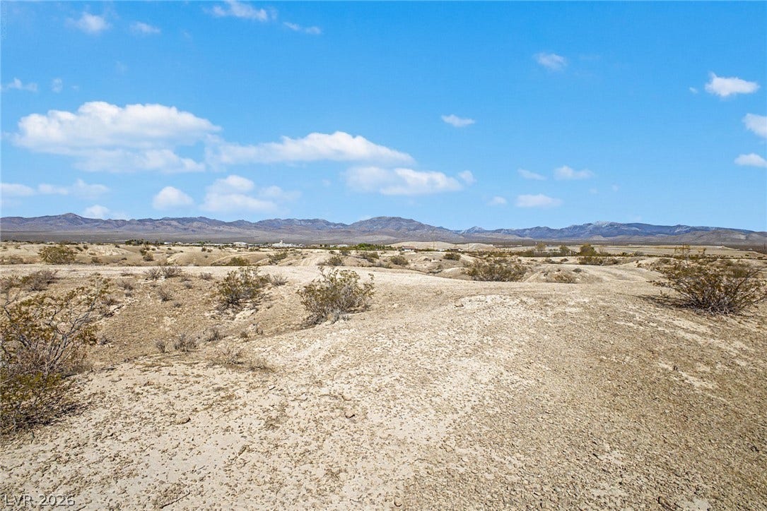 1621 Rockafeller Drive, Pahrump, NV 89060 Rolling desert terrain stretches toward distant mountain peaks under a clear blue sky.