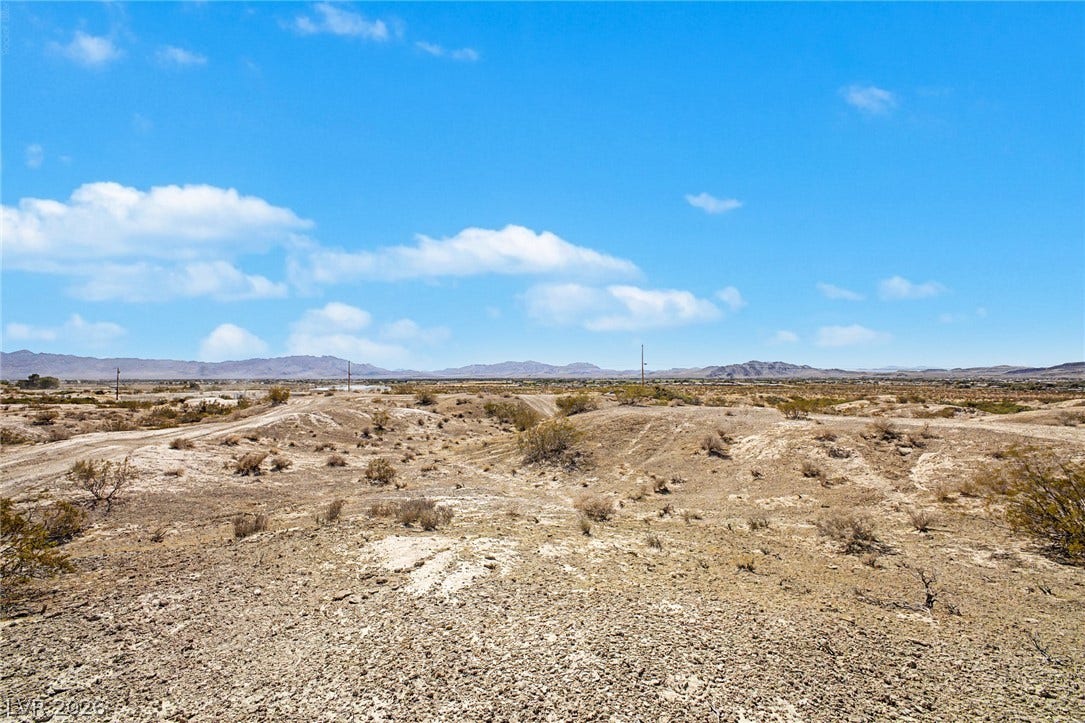 1621 Rockafeller Drive, Pahrump, NV 89060 Distant mountains frame this vast desert acreage under a bright blue sky.
