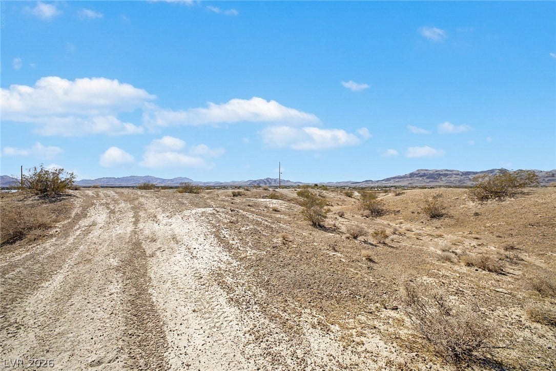 1621 Rockafeller Drive, Pahrump, NV 89060 Distant mountains frame this open desert lot under a clear blue sky.