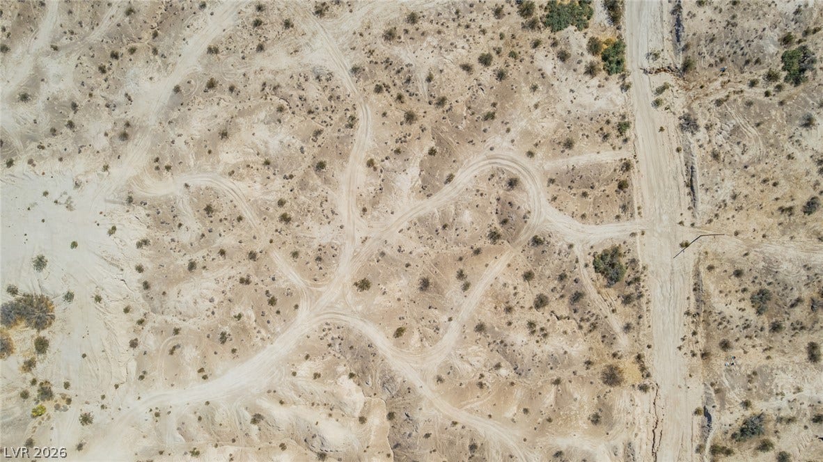 1621 Rockafeller Drive, Pahrump, NV 89060 Dirt tracks weave across a vast, brush-dotted desert parcel as seen from above.