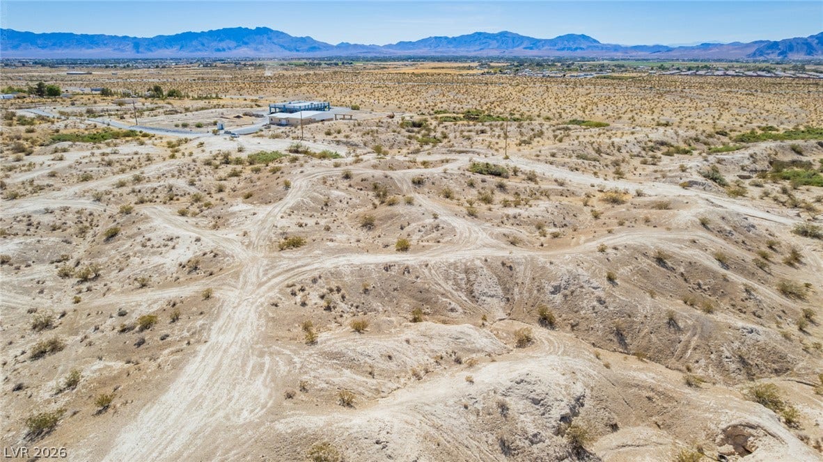 1621 Rockafeller Drive, Pahrump, NV 89060 Rugged desert terrain stretches toward majestic mountain peaks under a clear blue sky.