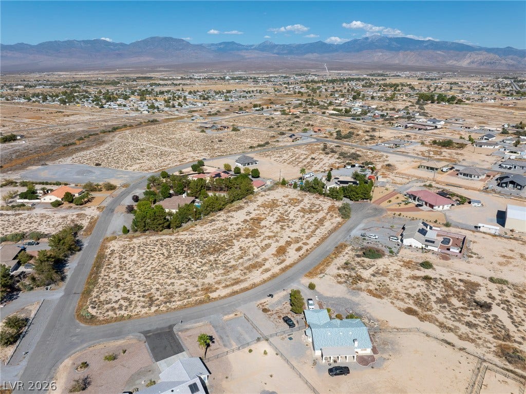 Majestic mountain ridges frame this expansive desert neighborhood under clear blue skies.