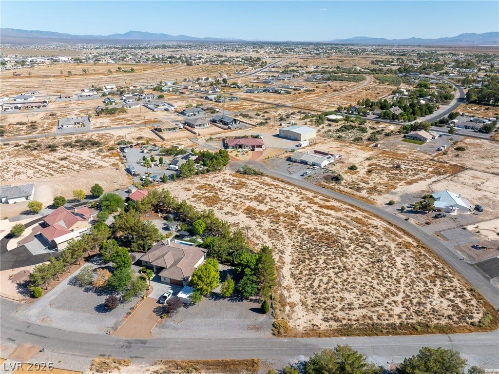 A spacious desert lot offers endless possibilities surrounded by mountains in the distance.