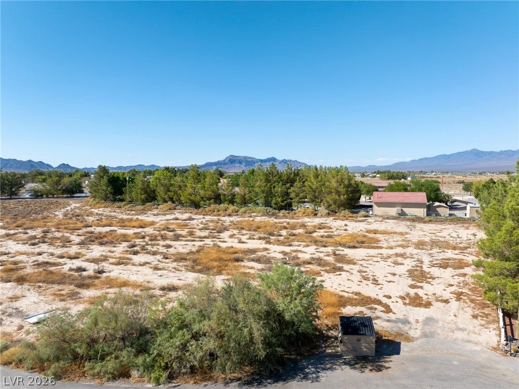 Distant mountain ranges frame this level desert landscape under a clear blue sky.
