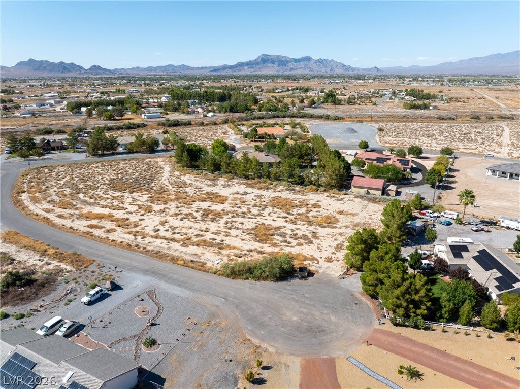 Panoramic mountain views surround this expansive desert property framed by paved street frontage.