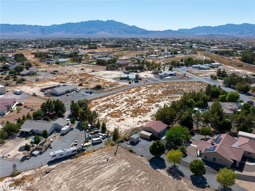 Distant mountains frame a vast desert landscape dotted with residential properties.