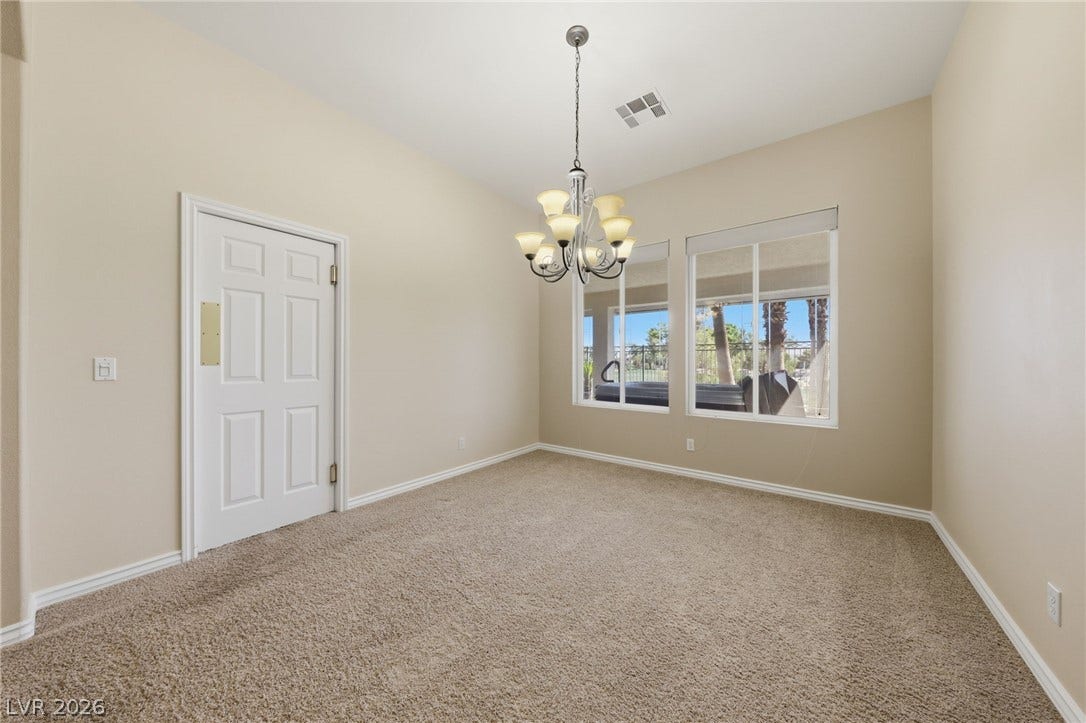 High ceilings and generous windows define this versatile carpeted dining area.