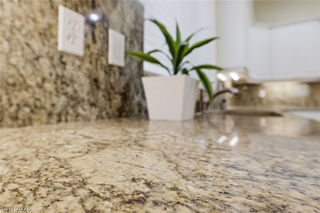 Gleaming granite countertops extend seamlessly along the kitchen workspaces.