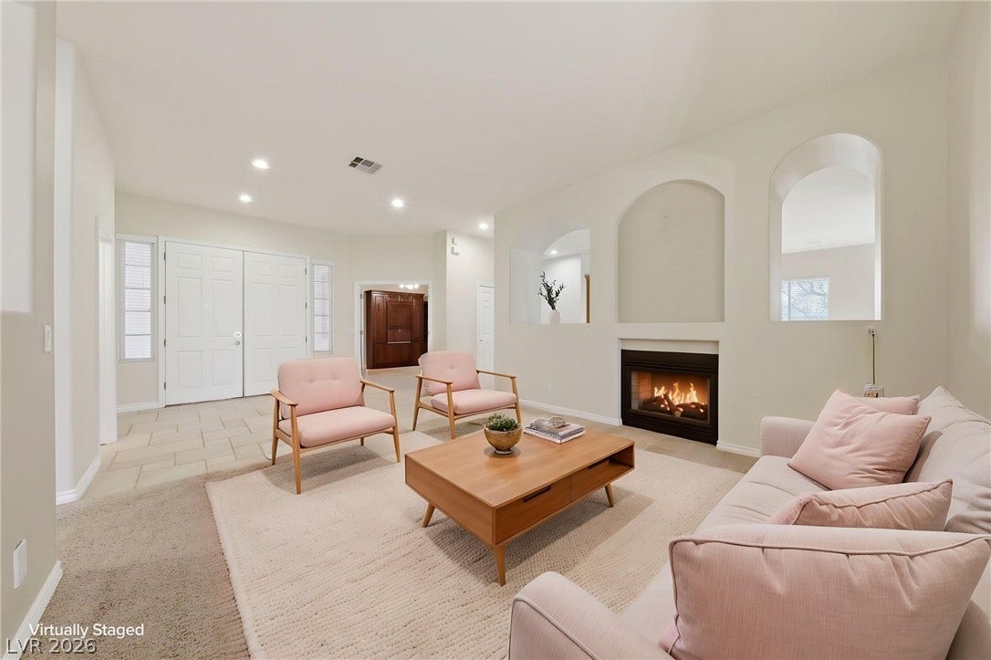 An inviting fireplace sets a cozy tone in this open living area with carpet flooring.