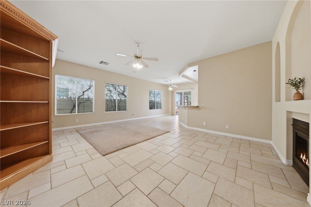 Tiled flooring and a modern fireplace elevate this versatile open living space.