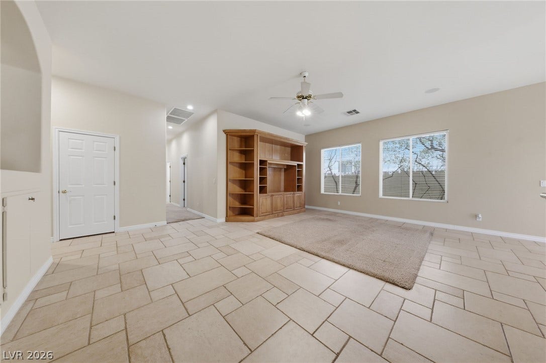 Tiled flooring and large windows enhance this welcoming living space with built-in shelving.
