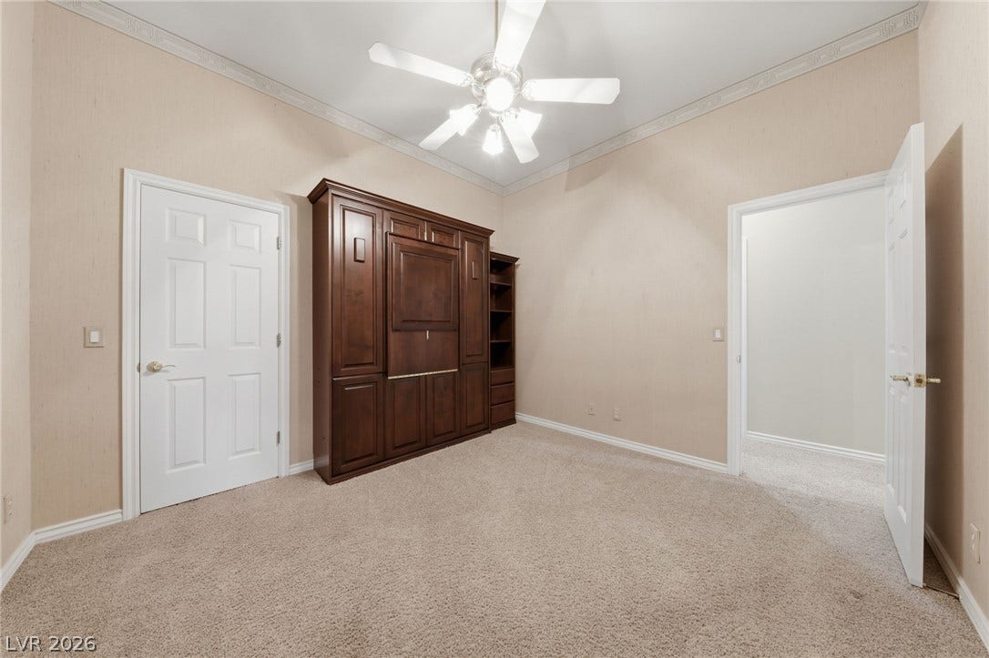 Rich wood built-ins complement the soft neutral tones and classic crown molding.