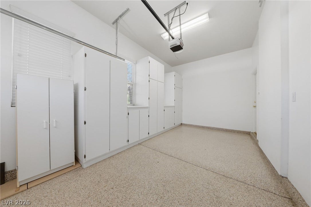 Ample built-in storage cabinets line the walls of this clean garage space.