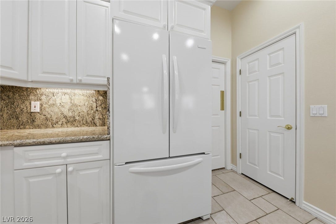 Granite countertops and clean tile flooring elevate this functional kitchen space.