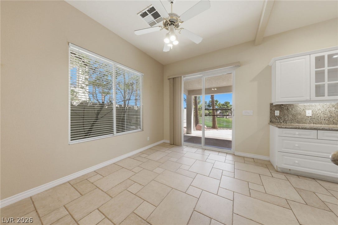 Tiled flooring and large windows bring abundant natural light into this versatile dining area.