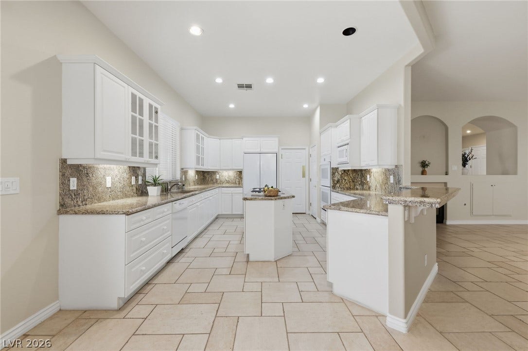 Tiled flooring runs throughout this spacious culinary space highlighted by granite countertops.