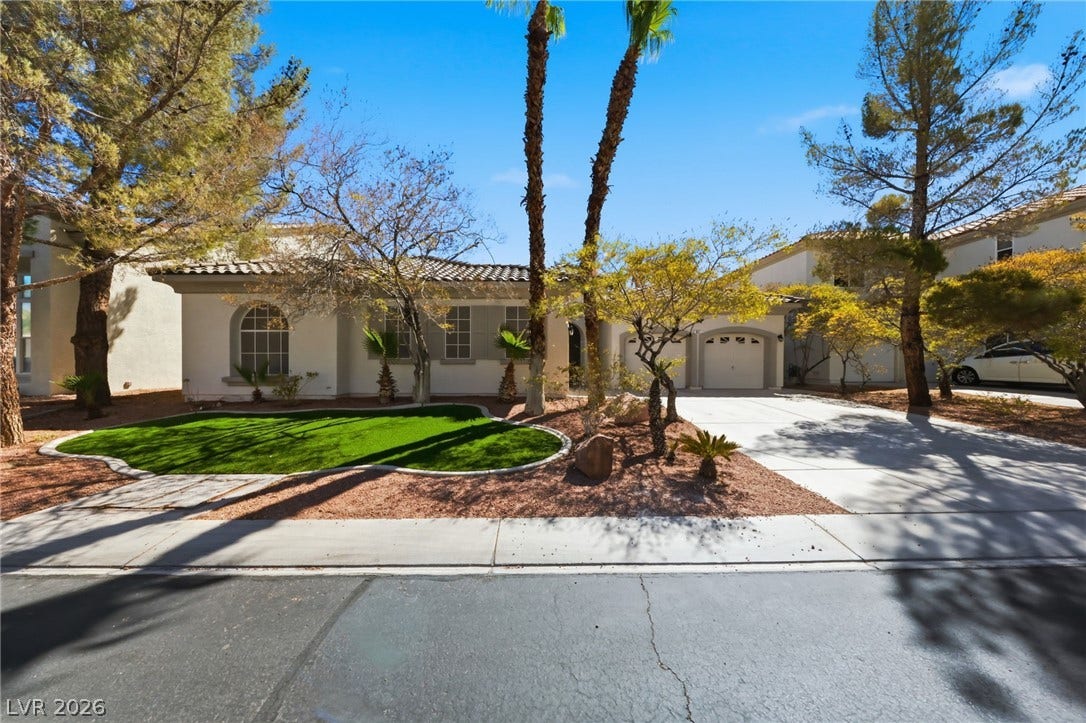 A classic stucco exterior frames the front of this home, complete with a tiled roof.
