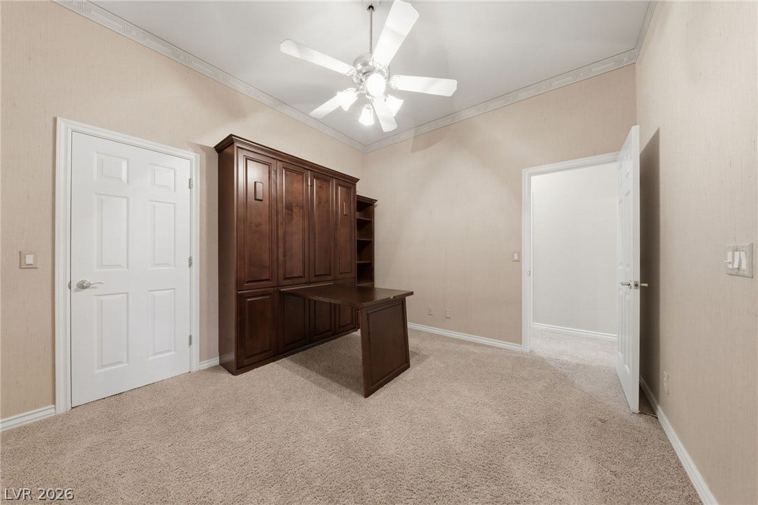 Rich wood built-ins complement the classic crown molding and soft neutral carpeting.